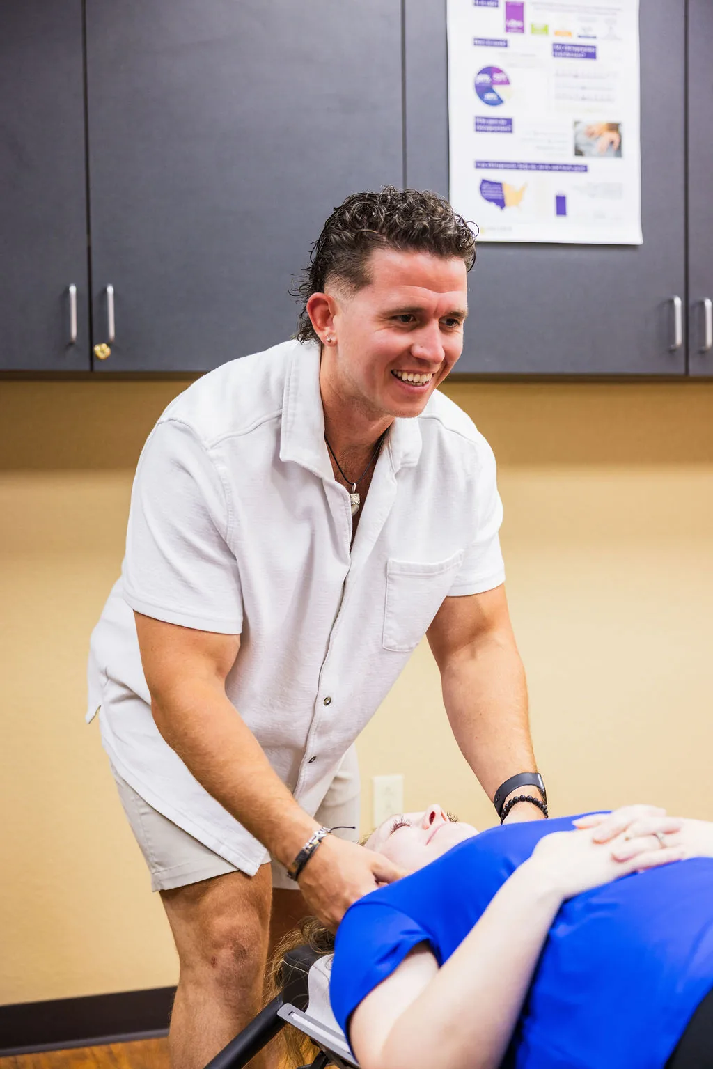 Dr. Levi Hansen performs a cervical adjustment on a patient lying on a treatment table.