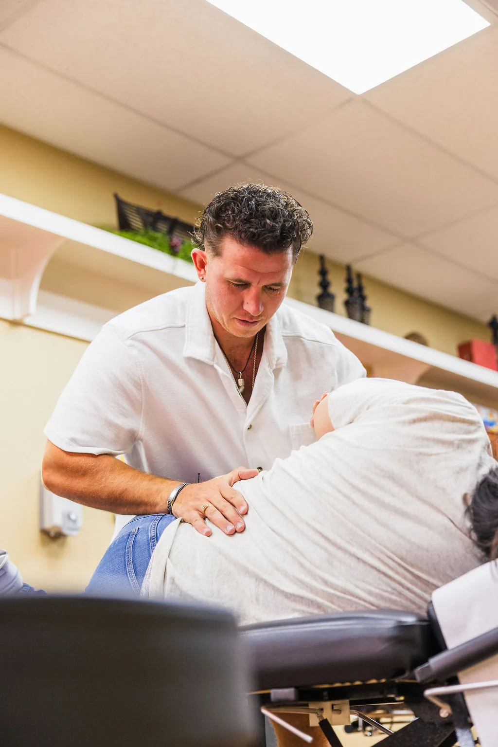 Dr. Levi Hansen performs a side-posture chiropractic adjustment on a patient resting on an adjustment table.