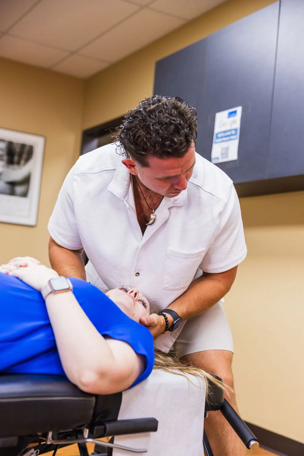 Dr. Levi Hansen performs a cervical adjustment on a patient resting on a treatment table.